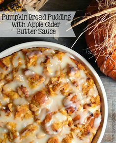 pumpkin bread pudding with apple cider butter sauce in a white dish on a wooden table