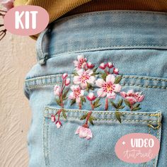 the back pocket of a pair of jeans with embroidered flowers