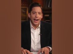 a man in a suit and tie holding a keyboard