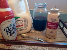 the contents of a milk carton sitting on top of a wooden table next to a bottle of yogurt