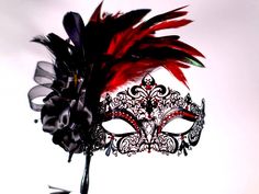 Masquerade mask, masquerade mask with stick and feathers, laser cut metal mask black and red crytals This a stunning masquerade metal laser cut mask with absolutely gorgeous rooster red feathers a black flower and a black stick and red matching beautiful gems.  If you wish this same style and design of mask to be without the stick please feel free to contact me I will be happy to make the change!  In my store I have a large variety of masquerade metal laser cut mask for masquerade ball parties, I have lace machine embroidered masquerade mask I embroider too and if you wish for the thread to be changed to match the occasion please feel free to contact me anytime!  In my store I have other designs of masks and metal laser cut with different designs and colors of gems and masks also items tha Red Fantasy Party Mask, Red Masquerade Mask For Mardi Gras Gift, Black Masks For Carnival, Venetian Black Masquerade Mask, Black Masks And Prosthetics For Carnival, Black Masks And Prosthetics For Carnival Gift, Red And Black Masquerade Mask, Mask For Masquerade Ball, Masquerade Ball Aesthetic