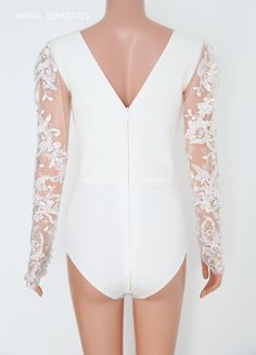 Handmade lace wedding Bodysuit by yours truly. Available and ready to ship in size x-small (0-2) Photos shown details: V- neck V-back Lace long sleeves Center back zipper closure Stretchy high quality knit bottom Materials :tulle, lace, knit Shop other BRIDAL BODYSUIT here : https://etsy.me/3ja1yEk Estimated shipping times : ✅Standard shipping: 3-6 weeks for most countries ✅Expedited shipping: 4-6 business days for most countries I'll do my best to meet these shipping estimates, but cannot guara Elegant Fitted Bodysuit With Sheer Bodice, Elegant Fitted Bodysuit With Sheer Sleeves, Elegant Lace Bodysuit For Parties, Elegant White Backless Bodysuit, Fitted Lace Bodice Bodysuit For Party, White Lace Party Bodysuit, Elegant Lace Trim Bodysuit For Evening, White Lace Bodysuit For Party, Elegant Party Bodysuit With Lace Trim