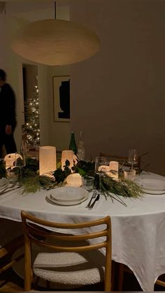 the table is set with candles, plates and napkins for dinner guests to enjoy