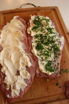 two pieces of meat on a wooden cutting board