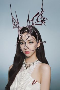 a woman with long black hair wearing a metal headdress that has birds on it