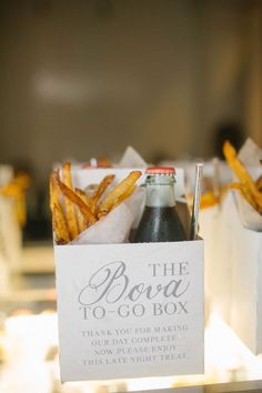 french fries in a box with a sign on the side that says the bona to go box