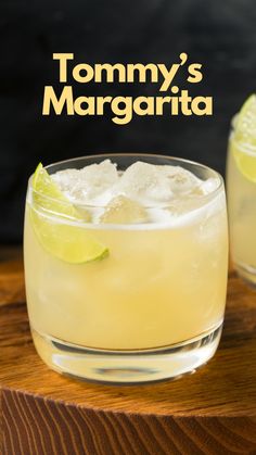 two glasses filled with lemonade and lime on top of a wooden table next to each other