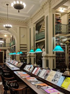 a long table with many books on it in a room filled with tables and chairs