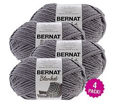 three balls of bernat yarn in grey, with the label on each ball and four packs