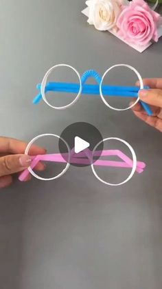 two hands holding glasses with pink and blue frames