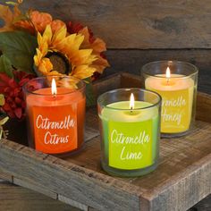 three candles sitting on top of a wooden tray