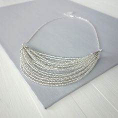 Silver Multi-strand Beaded Chain Beads, Silver Multi-strand Beaded Necklace, Tiny Beads Bib Necklaces For Jewelry Making, Silver Multi-strand Beaded Necklaces With Spacer Beads, Silver Multi-strand Beaded Necklace With Spacer Beads, Silver Necklace With Tiny Beads For Party, Layered Beaded Necklace, Elegant Statement Necklace, Layered Beaded Necklaces