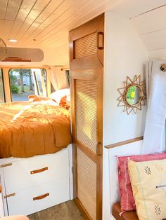 the inside of a camper with a bed and pillows