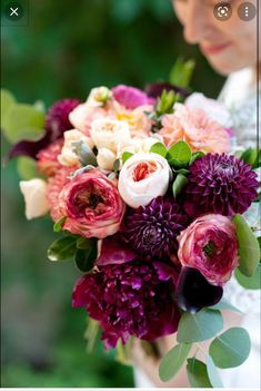 a woman holding a bouquet of flowers in her hands