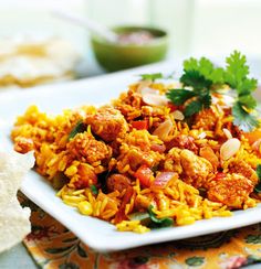 a white plate topped with rice and meat