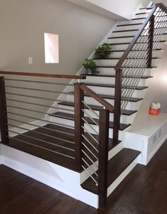 there is a stair case in the middle of this room with wood floors and white railings