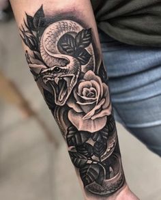 a man's arm with a snake and roses tattoo on the forearm, in black and white