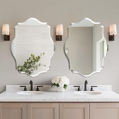 a bathroom with two sinks and mirrors on the wall