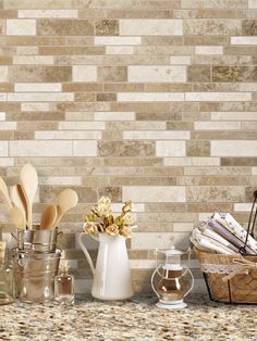 kitchen utensils lined up on a counter with tile back splash in the background