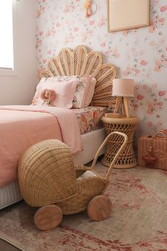 a bedroom with pink and floral wallpaper, wicker furniture and a rattan chair