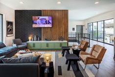 a living room filled with lots of furniture and a flat screen tv mounted to the wall