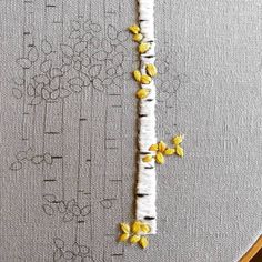 a close up of a piece of fabric with yellow flowers on it and a white background