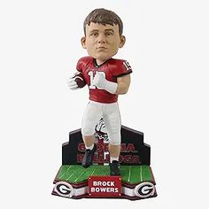 a bobble head figurine of a football player on top of a trophy