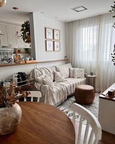 a living room filled with furniture next to a window covered in curtains and drapes