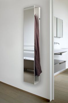 an open mirrored door in a white bathroom