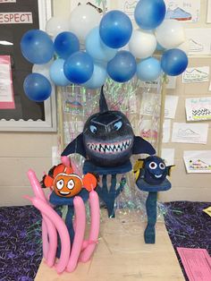 some balloons that are in the shape of an angry fish and other items on a table