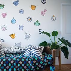 a living room filled with furniture and lots of wall stickers on the walls above it