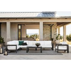 an outdoor living room with white couches and tables