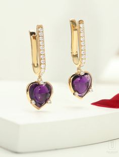 Heart-cut Amethyst earrings adorned with a cascade of diamonds, each one a reflection of the magnificent heart at its core. With every move they dance and shimmer and create an alluring aura of glamour and sophistication. Expertly crafted, the Lover's Rock Hoop Earrings feature a total gross weight of 7.28 grams, with a durable metal weight of 5.5 grams. Adorned with a stunning 8.29 carat gemstone and sparkling 0.62 carat cubic zirconia, these elegant earrings radiate sophistication and romance. Luxury Heart Cut Diamond Earrings, Luxury Diamond Earrings For Valentine's Day, Luxury Heart-shaped Diamond Earrings, Elegant Heart Gemstone Earrings For Valentine's Day, Luxury Heart Earrings With Diamond Accents For Formal Occasions, Elegant White Gold Huggie Heart Earrings, Elegant Gemstone Heart Earrings For Formal Occasions, Luxury Heart-shaped Diamond Earrings With Prong Setting, Elegant Formal Heart Gemstone Earrings