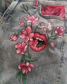 a pair of jeans with pink flowers painted on the front and side of each pocket