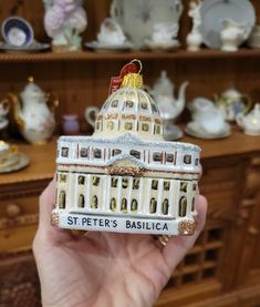 a hand holding up a christmas ornament that says st peter's basilica