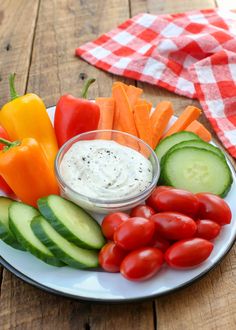 a white plate topped with vegetables and dip