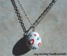 an egg with red, white and blue designs on it is sitting on a chain