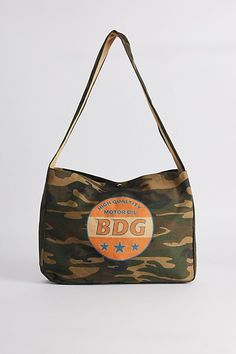 Camo pattern sling bag by BDG from UO with a logo graphic printed at the front. Snap top bag with a shoulder strap. Urban Outfitters exclusive. Features BDG graphic sling bag Camo pattern canvas bag BDG logo graphic Snap closure Shoulder strap UO exclusive Content + Care 100% Cotton Spot clean Imported | BDG Graphic Sling Bag in Green at Urban Outfitters Casual Shoulder Bag With Graphic Print For Travel, Casual Shoulder Bag With Graphic Print For Daily Use, Casual Shoulder Bag With Graphic Print, Casual Canvas Shoulder Bag With Graphic Print, Travel Cotton Shoulder Bag With Logo Print, Casual Logo Print Shoulder Bag For Travel, Casual Shoulder Bag With Logo Print For Travel, Casual Travel Shoulder Bag With Logo Print, Travel Shoulder Bag With Logo Print In Cotton