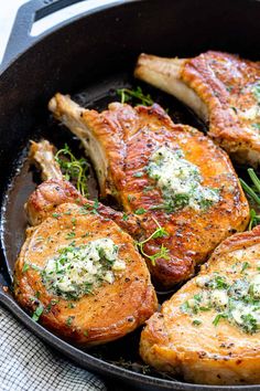 pork chops in a cast iron skillet with herbs