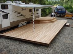 an rv is parked next to a wooden deck