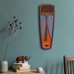 an animal statue sitting on top of a wooden table next to a vase with flowers