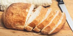 a loaf of bread sitting on top of a wooden cutting board next to a knife