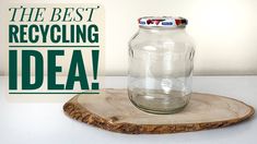 a glass jar sitting on top of a wooden board next to a sign that says the best recycling idea