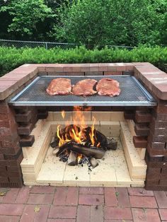 an outdoor bbq grill with steaks cooking on it's sides and fire in the middle