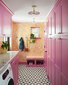 a laundry room with pink cabinets and tile flooring