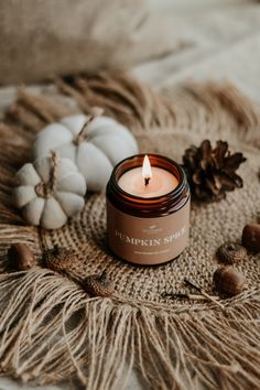 a candle sitting on top of a blanket next to some nuts and acorns