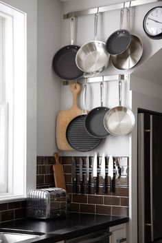 a kitchen with pots and pans hanging on the wall next to a stove top