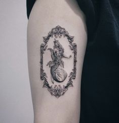 a black and white photo of a mermaid tattoo