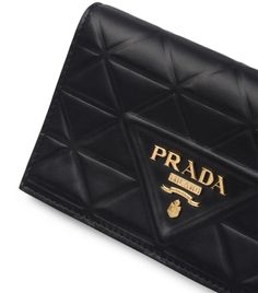 First conjured in 1913 by founder Mario Prada, Prada’s coveted Triangle makes its way onto a range of leather accessories like this wallet. The piece is centred around its gold-tone hardware, placed upon a quilted leather backdrop, evoking a repeated celebration of the Italian House’s favourite shape to elevate every transaction with heritage cues. Metal Lettering, Small Leather Wallet, Italian House, Quilted Purses, Wallets For Women Leather, Triangle Logo, Small Quilts, Diamond Quilt, Quilted Leather