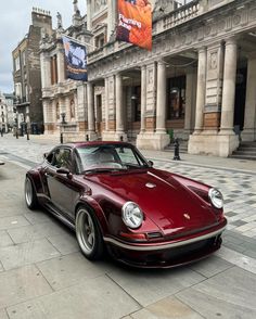 a red porsche parked in front of a building